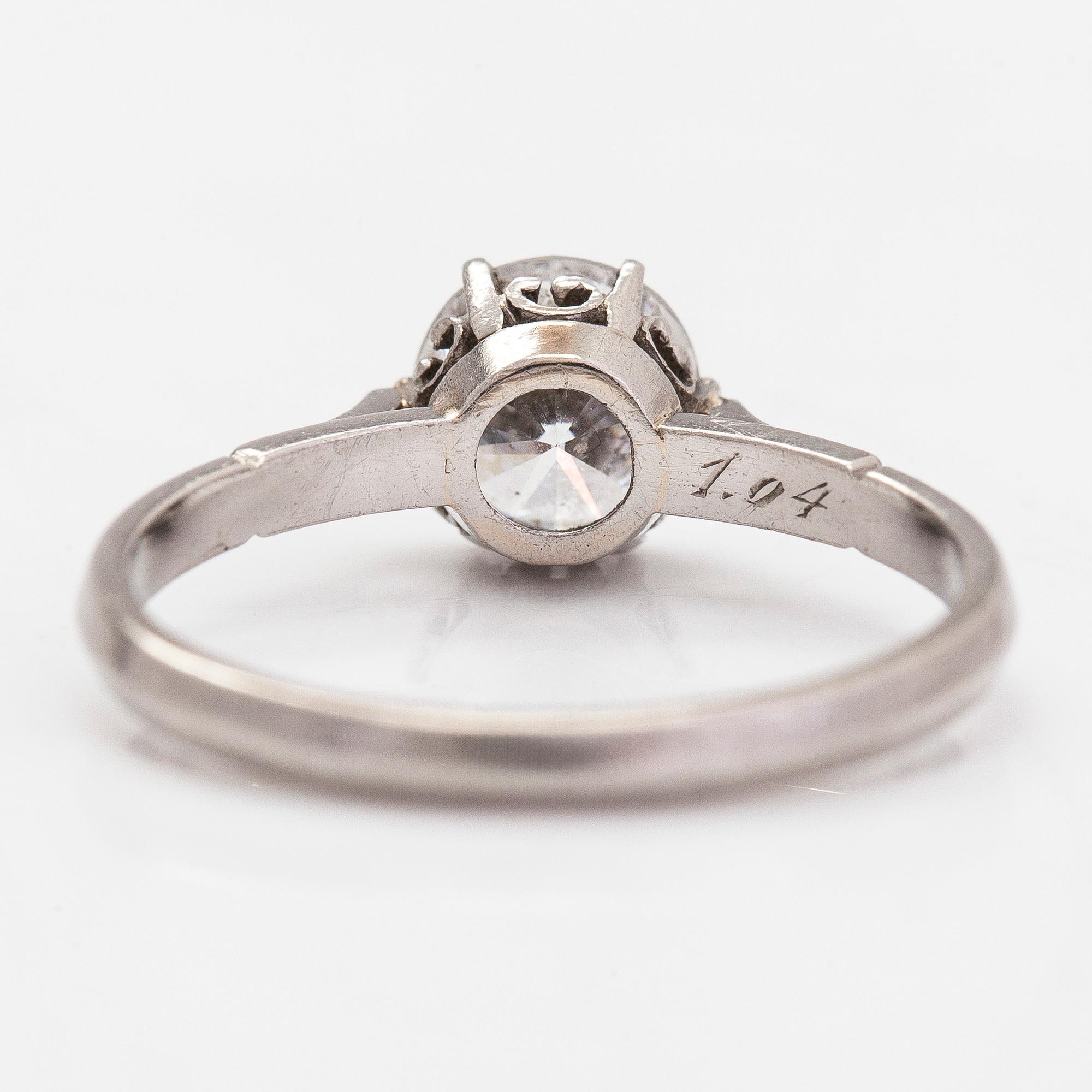 Sormus, platinaa, briljanttihiottu timantti 1.04 ct kaiverruksen mukaan. J.A Tarkiainen, Helsinki. Todistuksella.