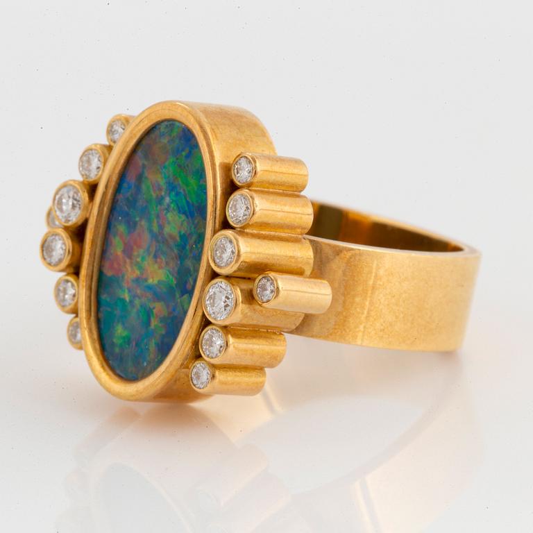 An 18K gold and opal ring set with round brilliant-cut diamonds.