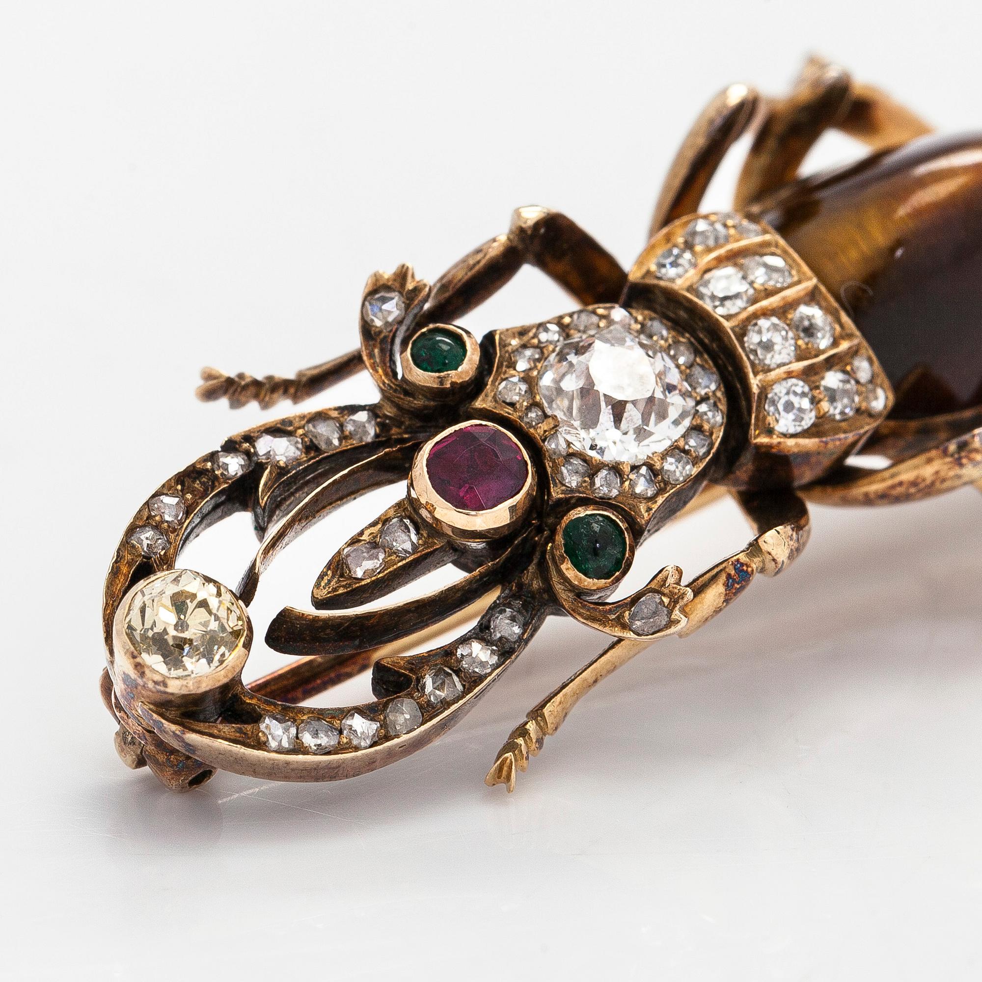 A 14K gold brooch with tiger’s eye, old-cut and rose-cut diamonds, ruby, emeralds. St. Petersburg.
