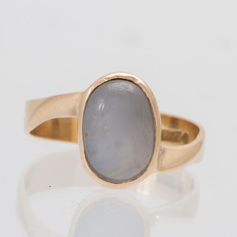 An 18K gold ring set with a cabochon-cut purple star sapphire, Rune W Andersson Uddevalla 1964.