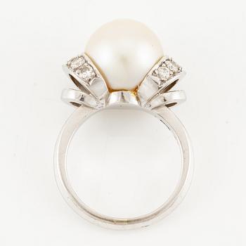 A ring in 18K white gold with a cultured pearl and round brilliant-cut diamonds.
