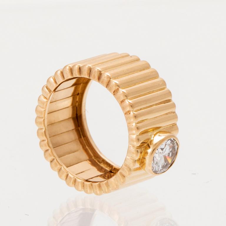 An 18K gold solitaire ring with a round brilliant-cut diamond.