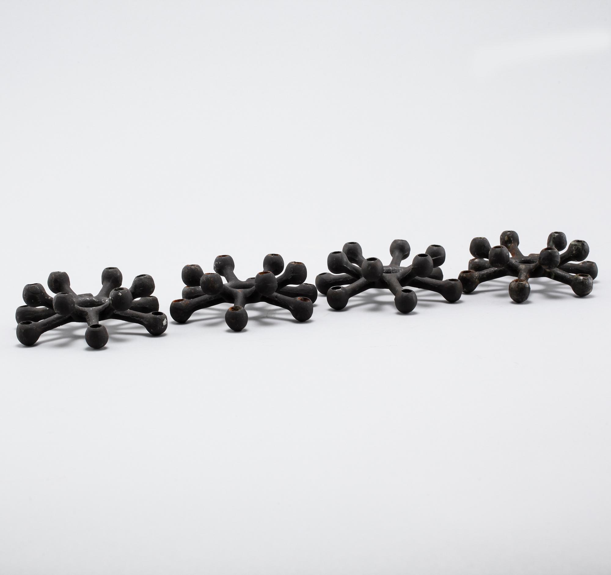 Four 1960s iron cast candle holders, designed by Jens Quistgaard for Dansk Designs .