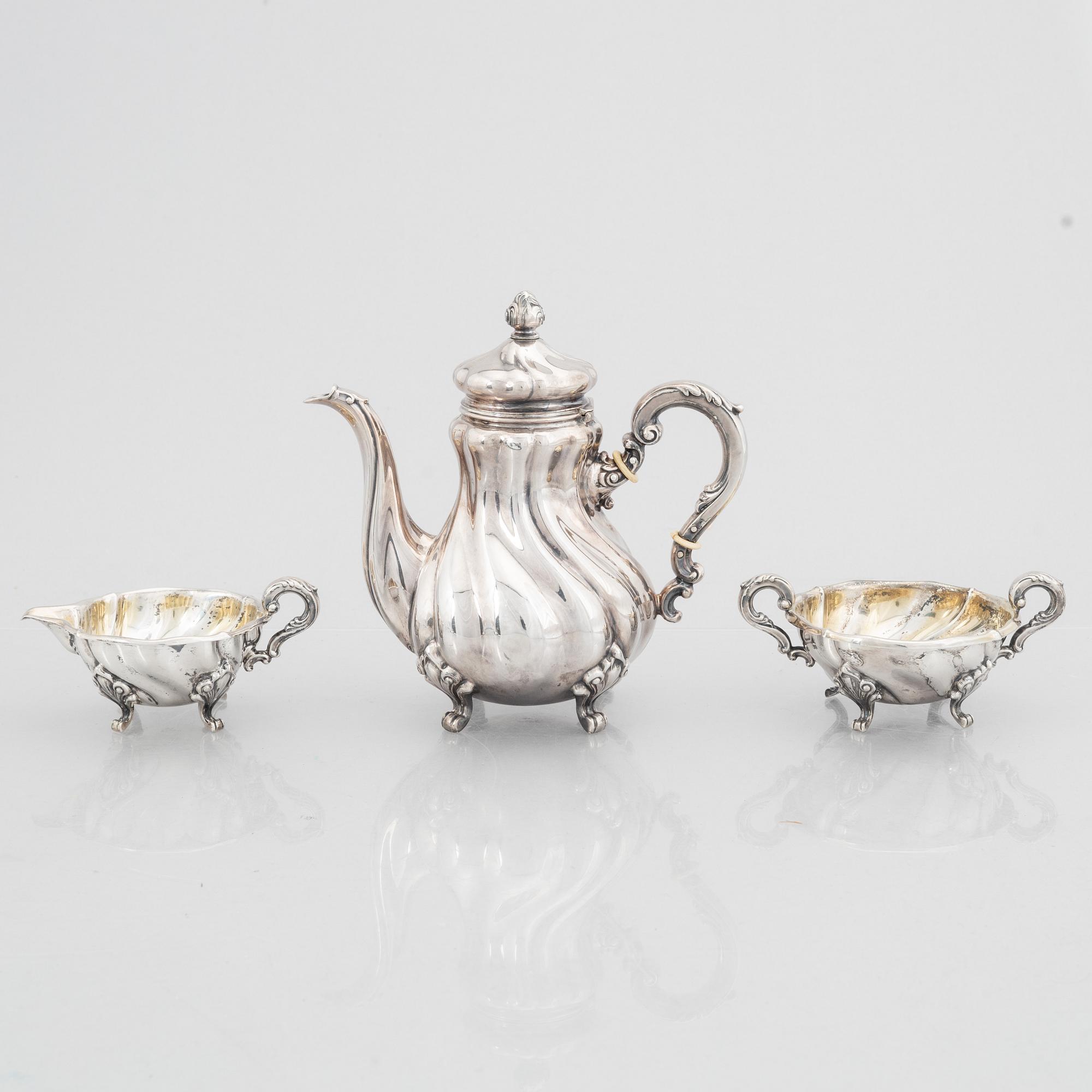 A Rococo Style Silver Coffee Pot, Creamer and Sugar Bowl, 20th Century, Swedish import mark.
