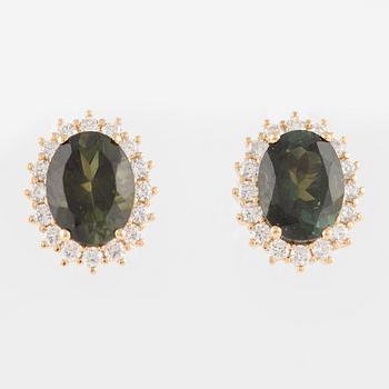 A pair of earrings in 18K gold with green faceted tourmalines and round brilliant-cut diamonds.