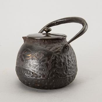 A Japanese iron tea pot with bronze cover, signed.