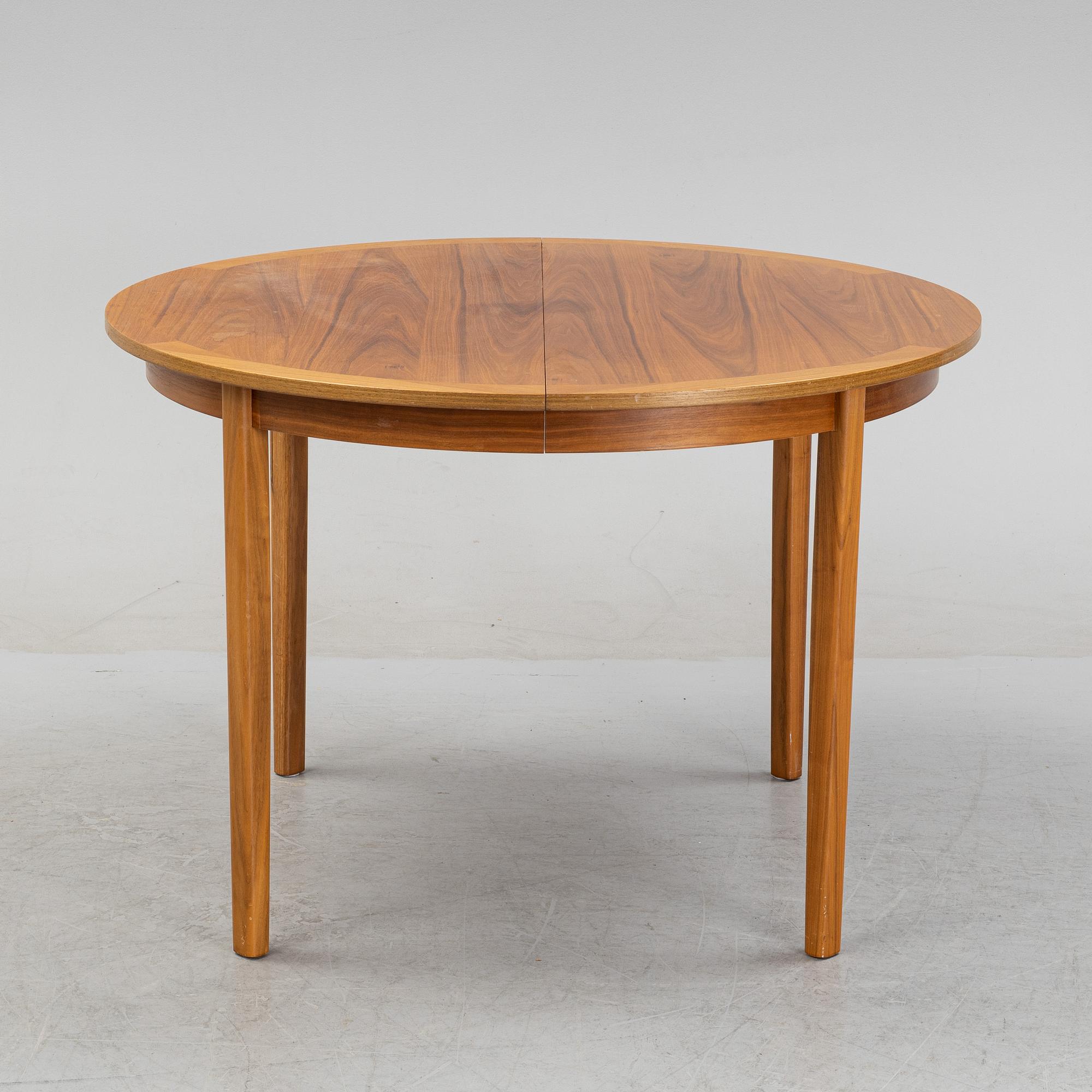 A round walnut veneered dining table.