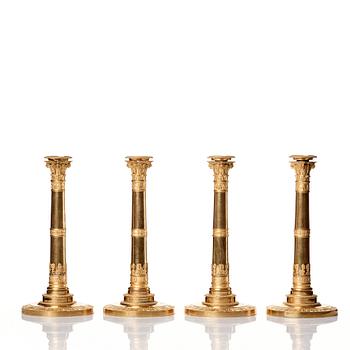 A set of four Empire presumably Russian candlesticks in gilded bronze.