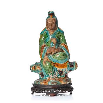 1040. A green, turquoise, yellow and aubergine glazed figure of Guanyin, late Ming dynasty (1368-1644).