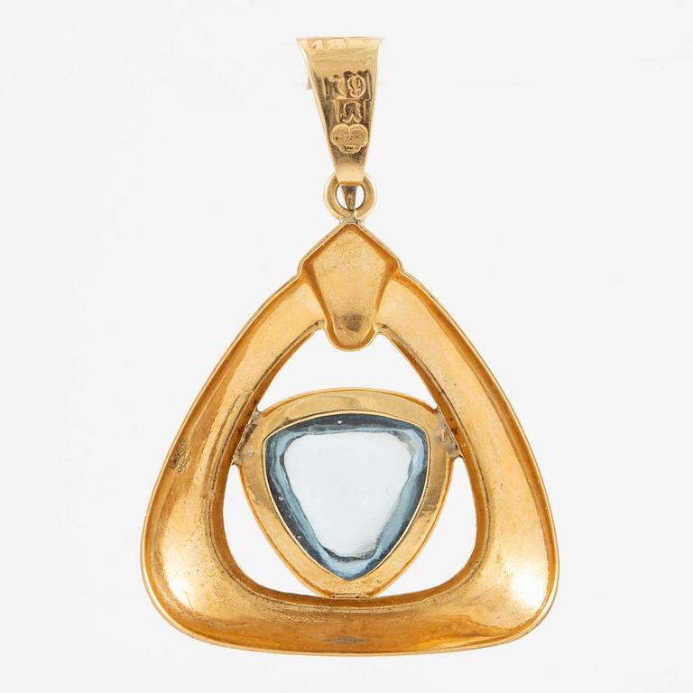 Pendant in 18K gold with a blue stone.