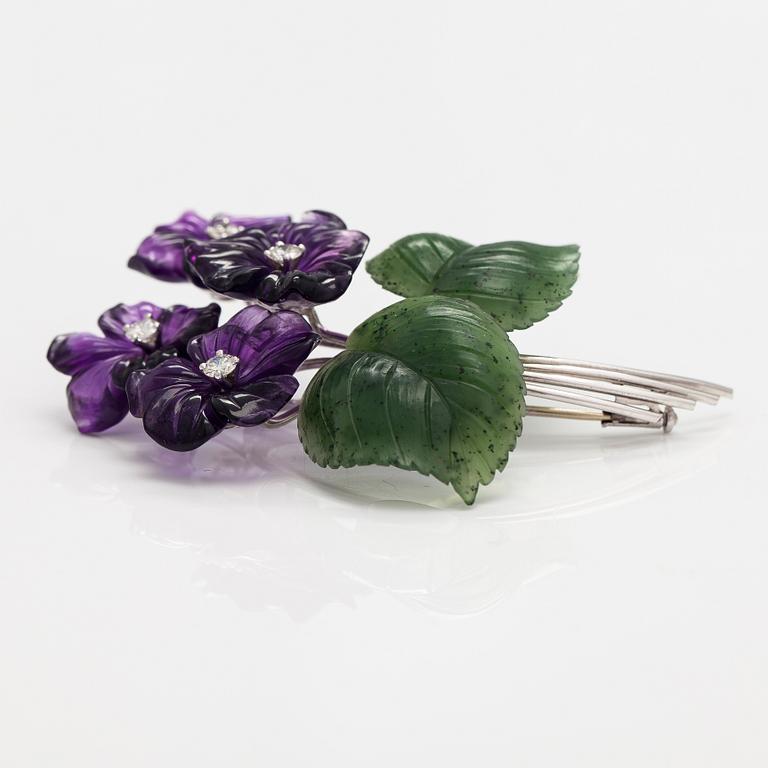 A flower brooch made of 18K white gold, carved amethysts and nefrites with ca. 0.64 cts of diamonds.