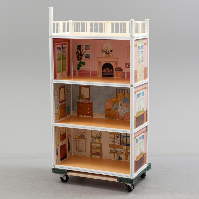 A plastic doll's house with six dolls, furniture and clothes, 20th century.