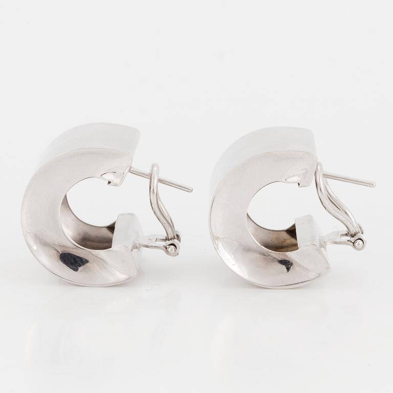 A pair of wide, hoop earrings.