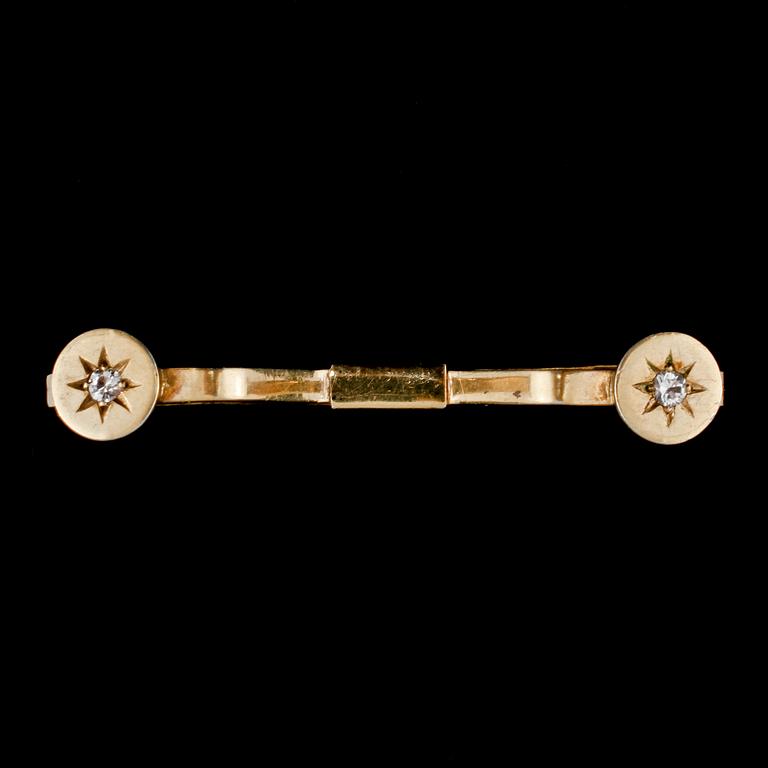 SPÄNNE, 18k guld med 2 briljantslipade vita stenar, Nils Ahlström, Borås, 1953. Vikt 6 g.