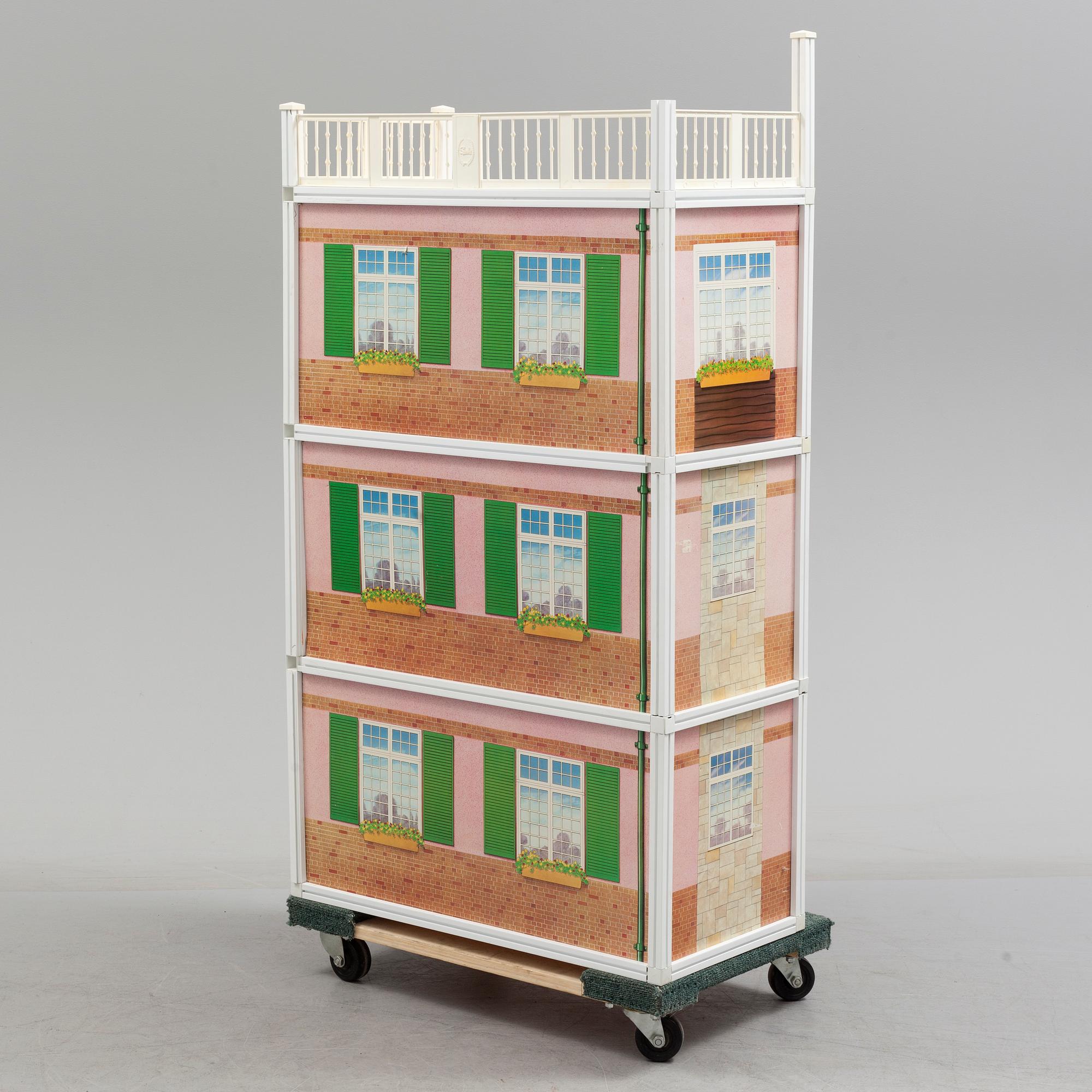 A plastic doll's house with six dolls, furniture and clothes, 20th century.