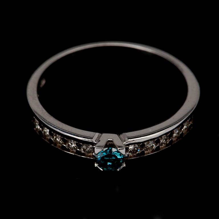 RING, vitguld 14K samt briljantslipade diamanter. Blåfärgad mittsten 0,10 ct. Vikt 1,8 g.