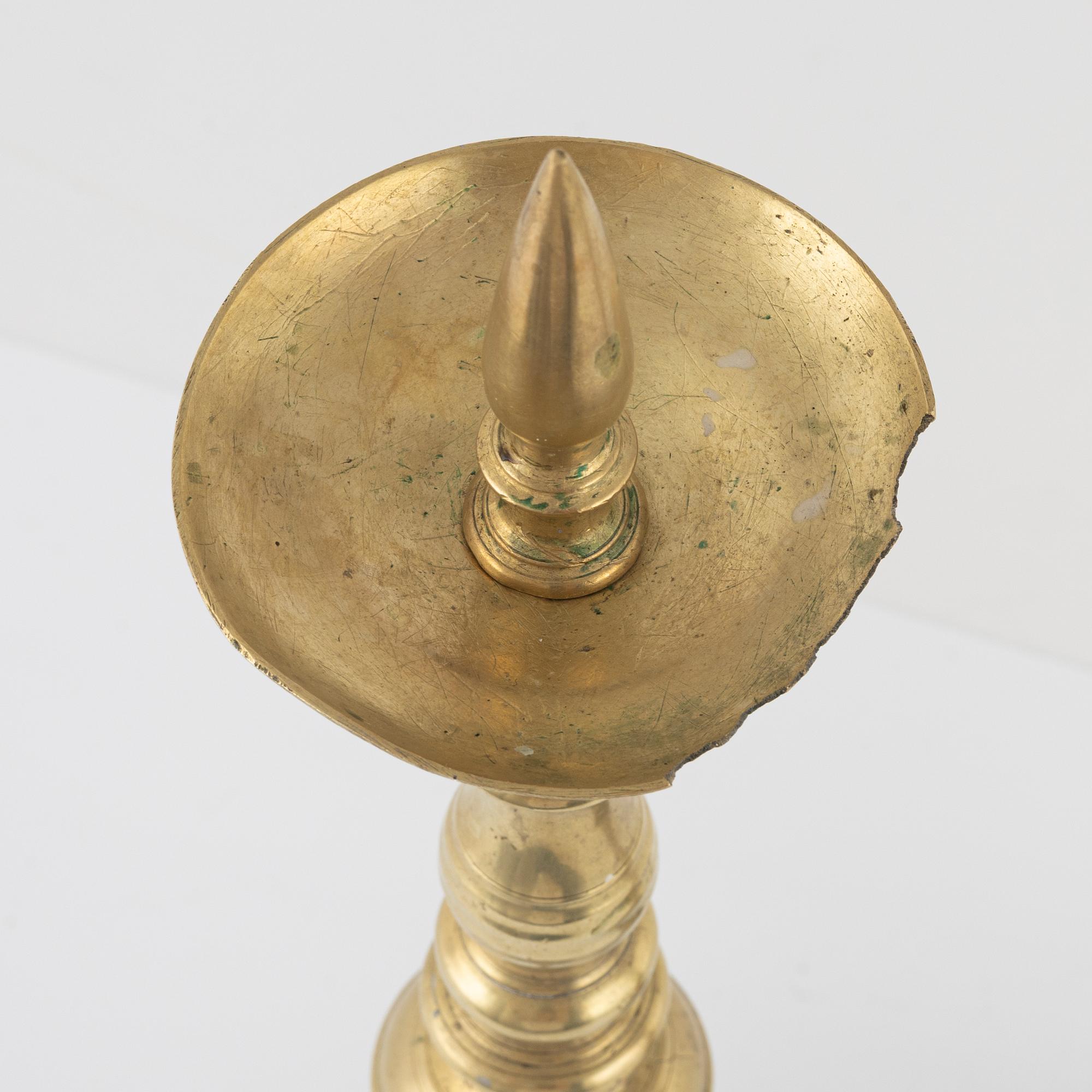 A pair of brass candle sticks, around 1700.