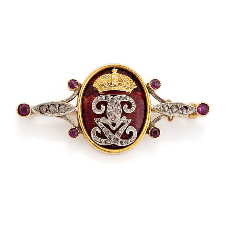 An 18K gold and enamel brooch set with rose-cut diamonds and faceted rubies.