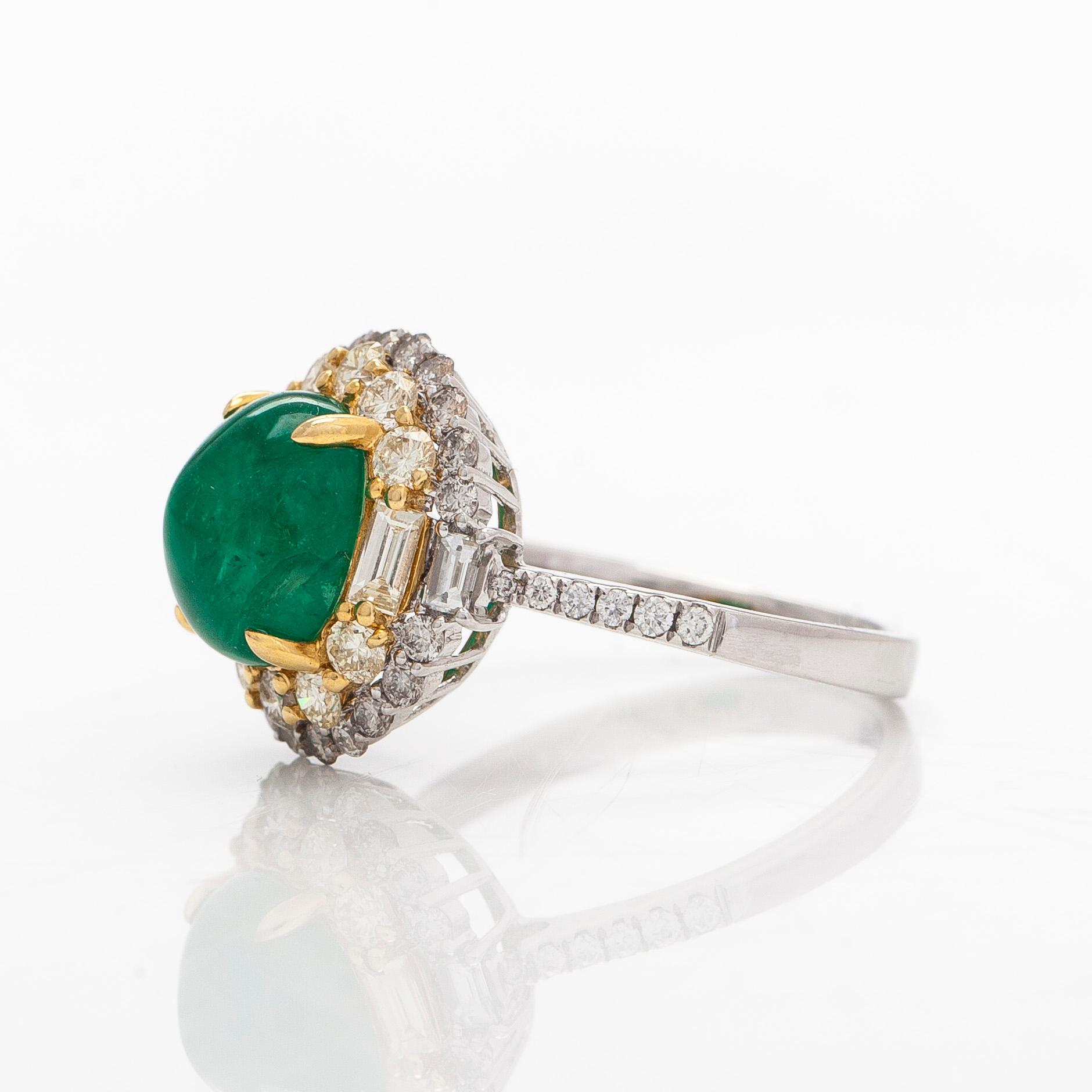 An 18K whitegold ring set with a cabochon-cut emerald and baguette- and brilliant-cut diamonds.