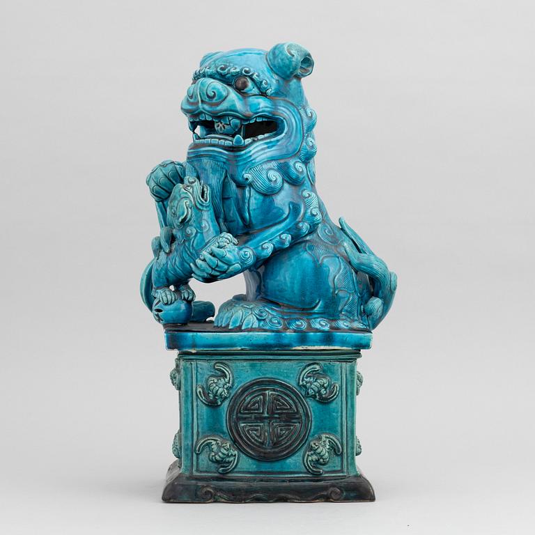 A Chinese seated buddhist lion on a plinth, 20th century.