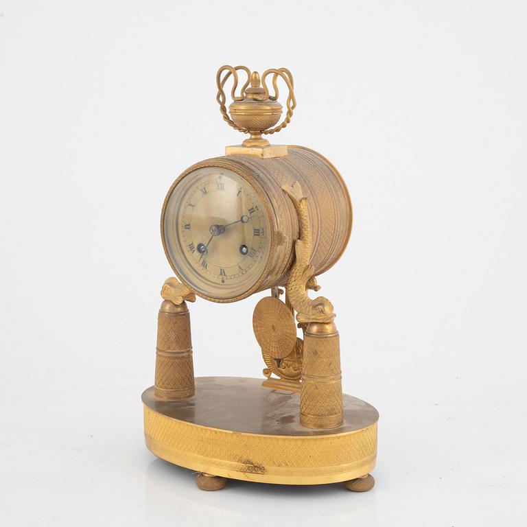 An Empire-style gilt bronze mantel clock and a pair of candlesticks, 20th century.