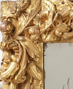 A presumably Dutch Louis XIV carved giltwood frame with mirror glass, in the style of Jean Le Pautre, late 17th century.