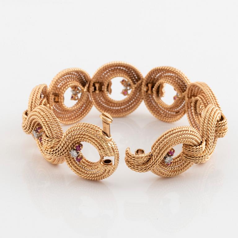 An 18K gold bracelet set with round brilliant-cut diamonds and rubies.