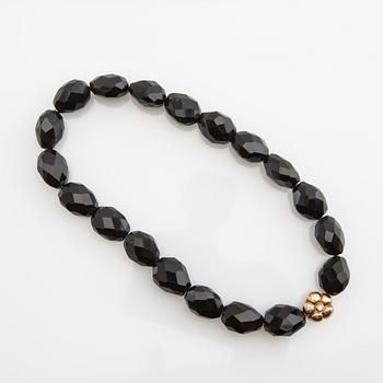 Ole Lynggaard, clasp, 18K gold with a round brilliant-cut diamond, and two necklaces.