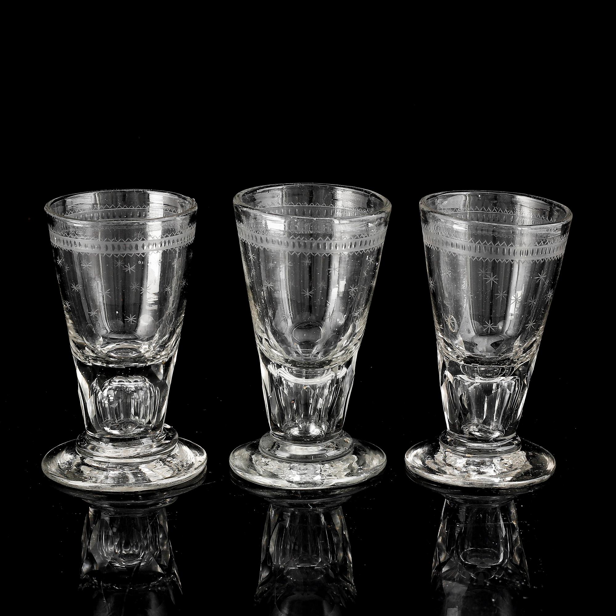 A glass bottle and three vodka glasses, 19th Century.