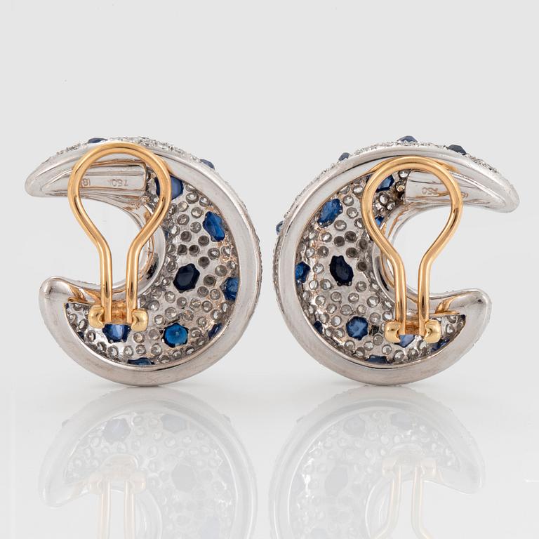 A pair of 18K gold earrings set with round brilliant-cut diamonds and faceted sapphires.