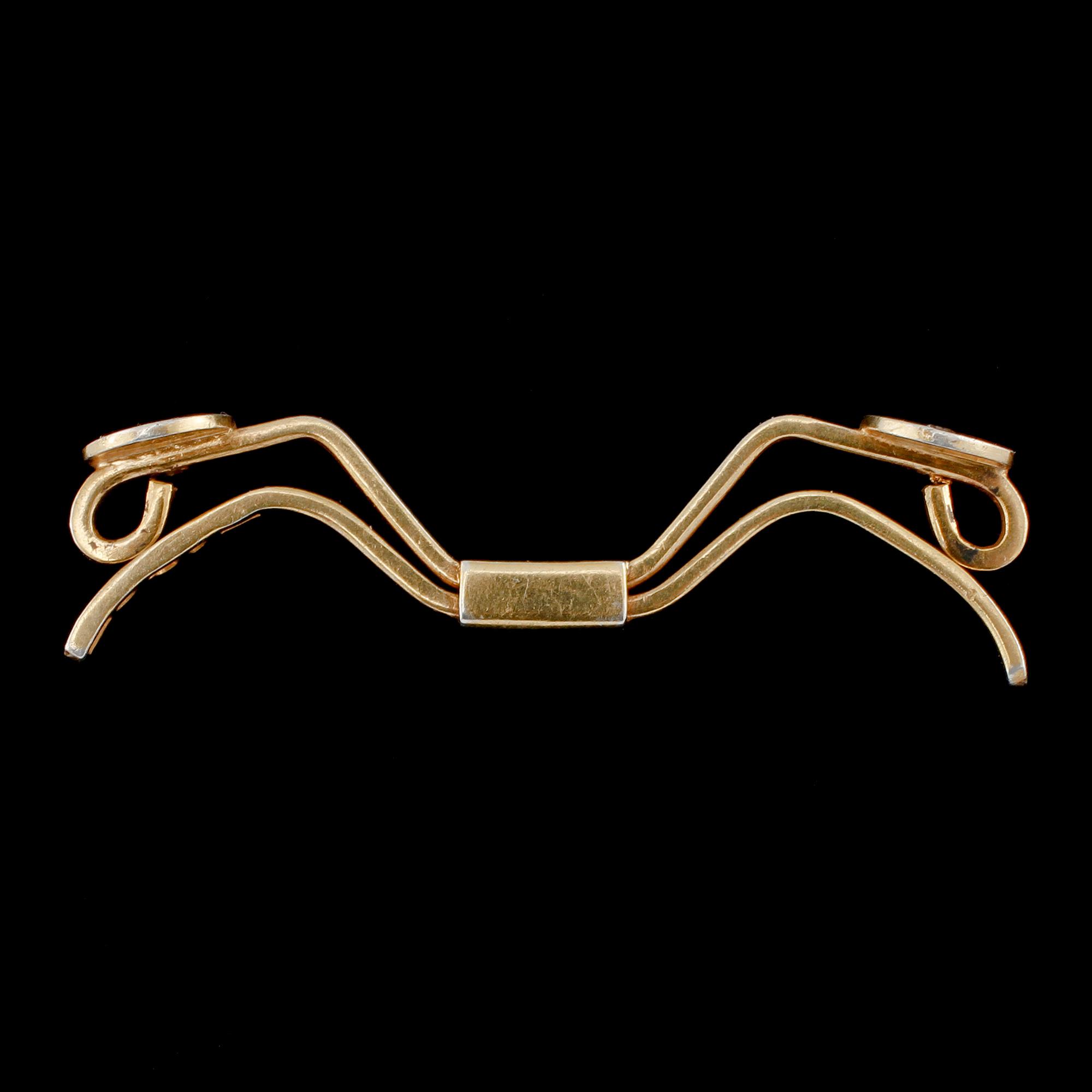 SPÄNNE, 18k guld med 2 briljantslipade diamanter, Nils Ahlström, Borås, 1953. Vikt 6 g.