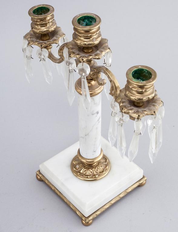 A French mantlepiece clock and a pair of candelabras, first half of the 20th century.