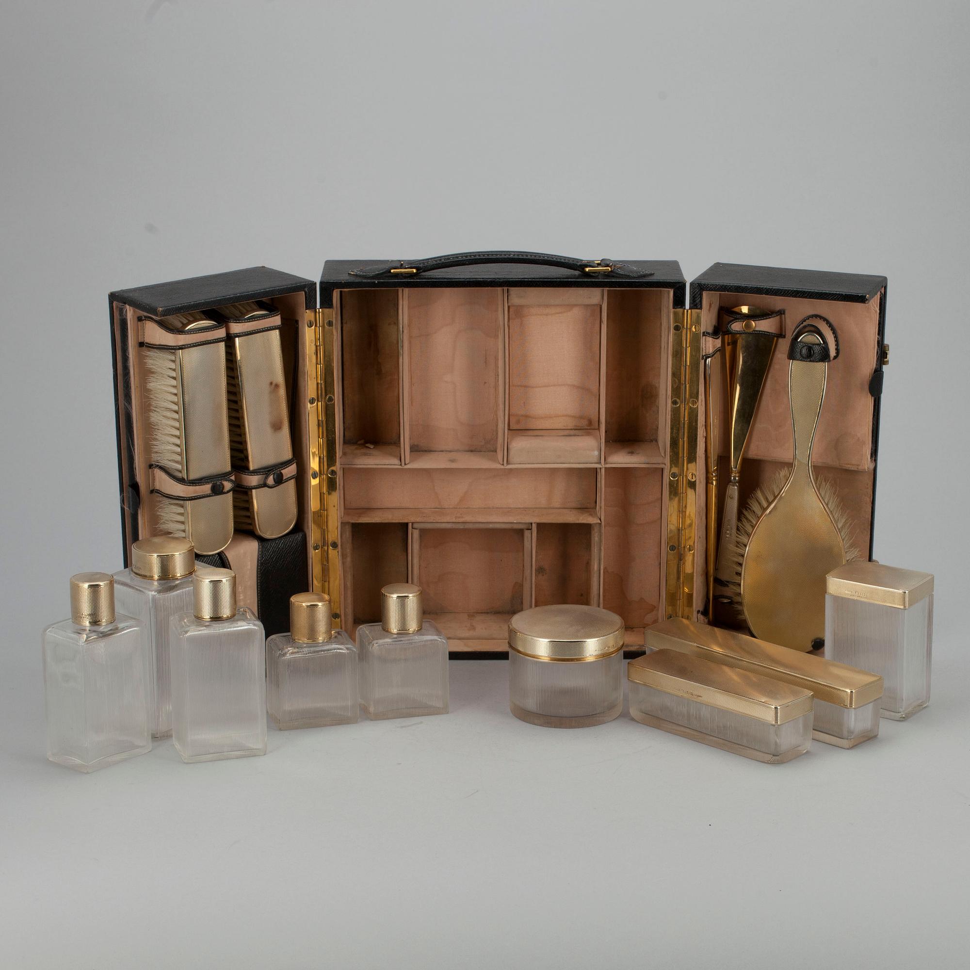 TOILETTESET I ETUI, 20 delar, förgyllt silver och glas. G.H. James & Co, London 1929.
