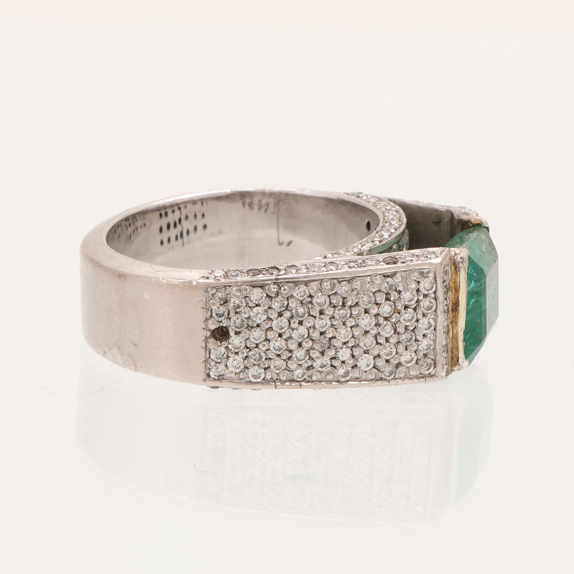 A 9K white gold ring with an emerald and brilliant cut diamonds.