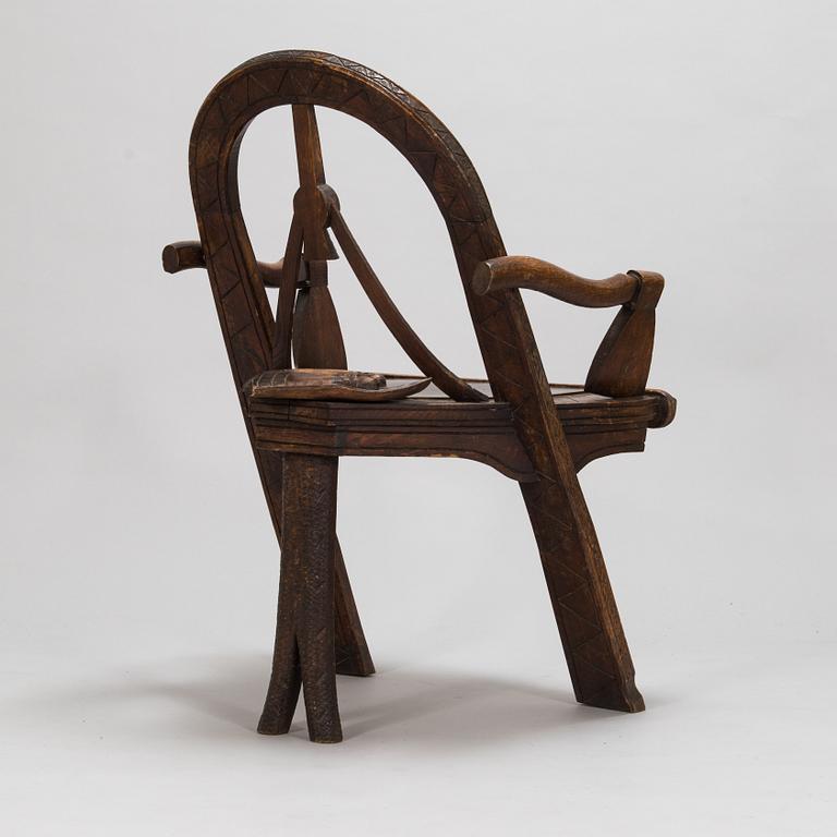 A carved oak wood armchair after V.P. Shutov's design "Arch, axe and gloves", Russia, late 19th century.