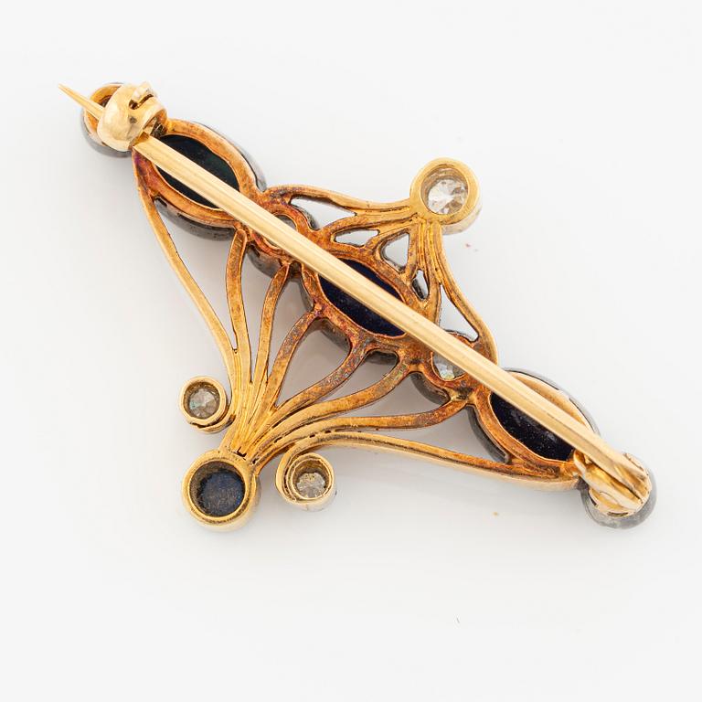 Brooch 18K gold and platinum set with step-cut sapphires and round brilliant-cut diamonds.