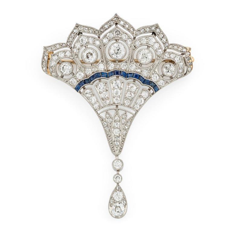 A platinum brooch with round brilliant, eight-, and rose-cut diamonds and calibré-cut sapphires.