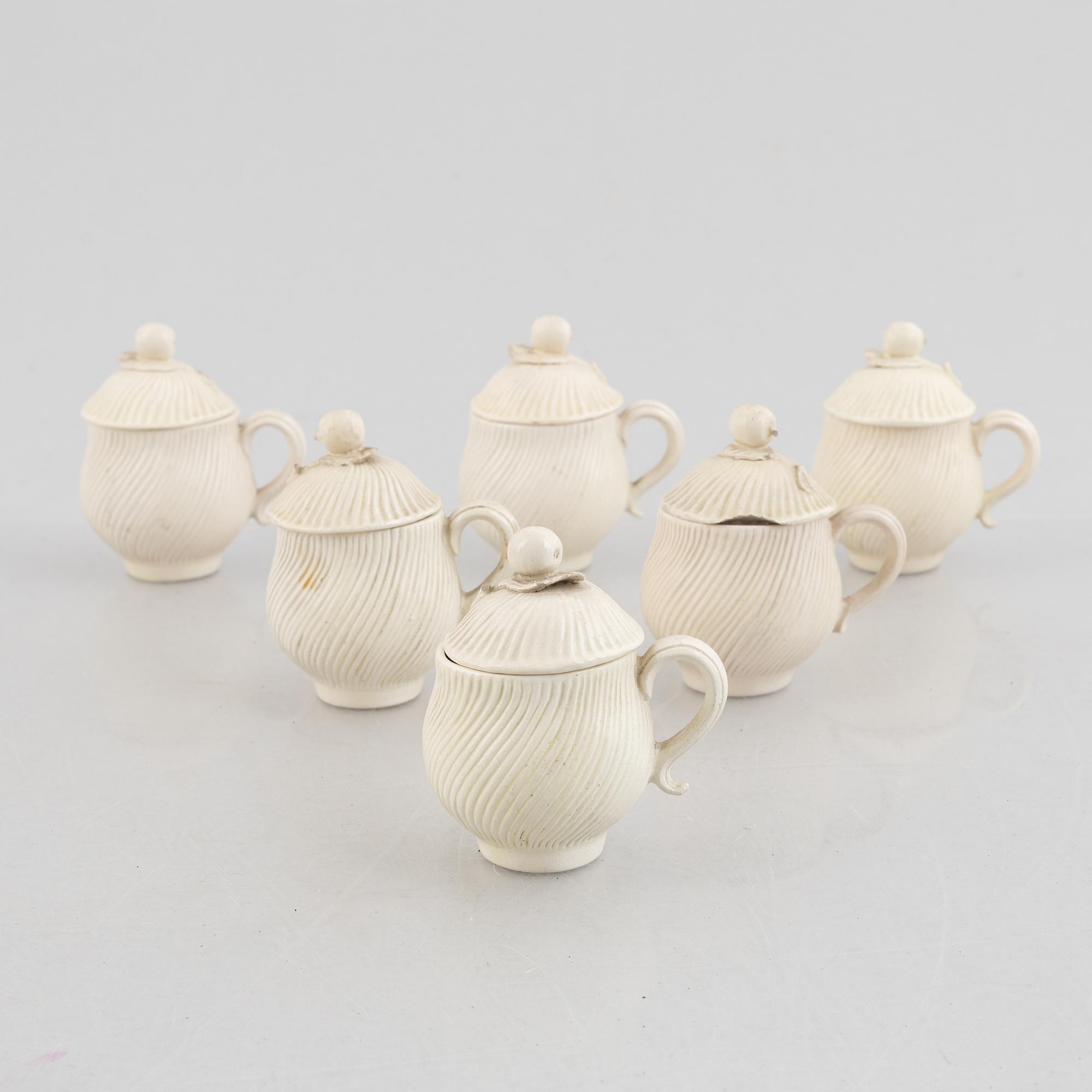 A set of six soft-paste porcelain custard cups with covers, 18th century.