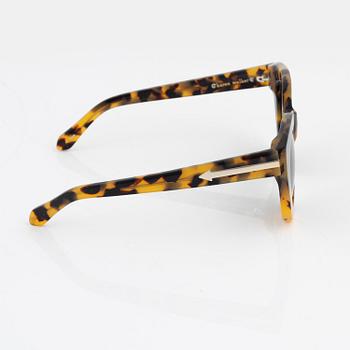 Karen Walker, a pair of tortoise "Anytime" sunglasses.