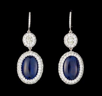 1012. A pair of cabochon cut blue sapphire, 7.67 / 6.92 cts, and diamond earrings.