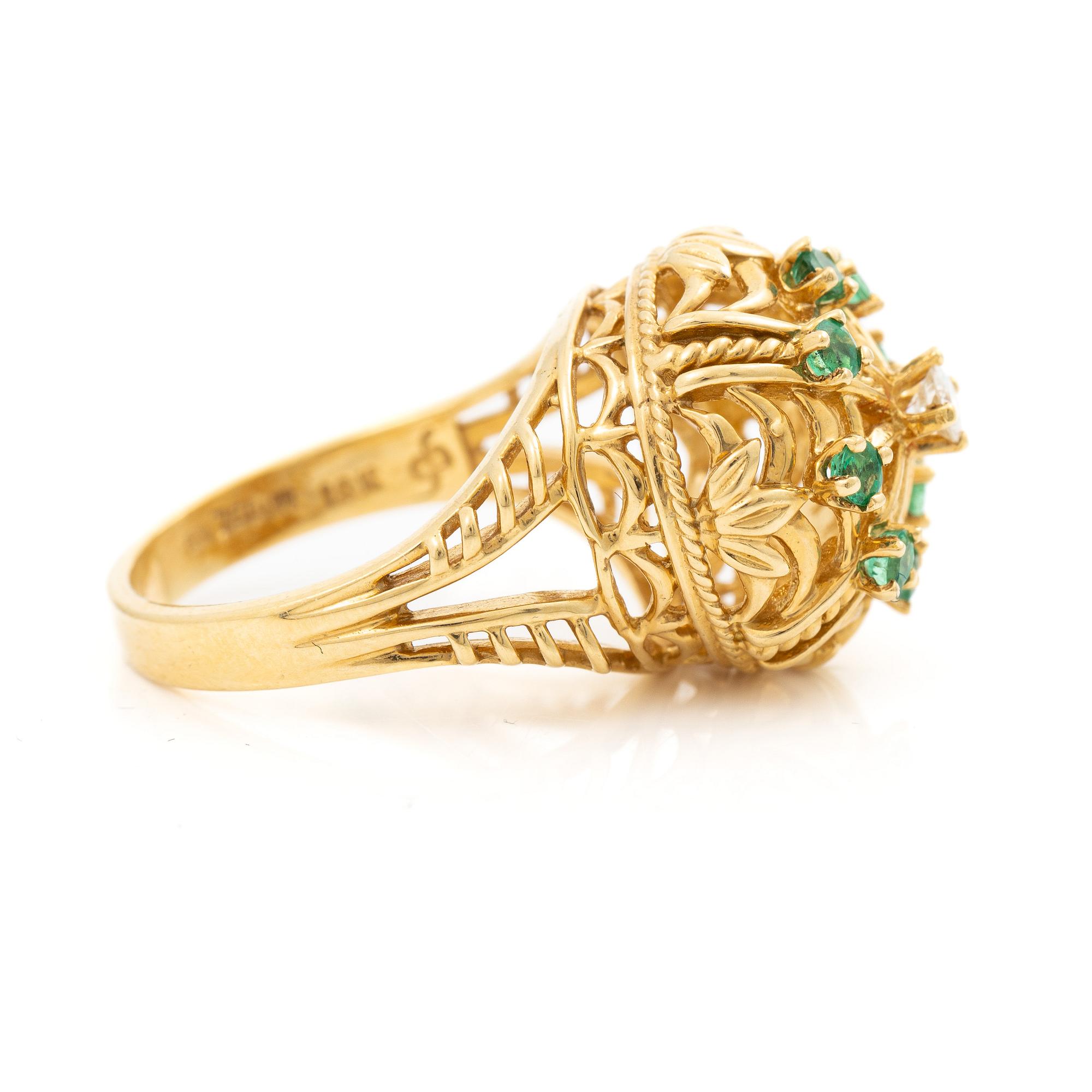 18K gold ring with small emeralds and a round brilliant-cut diamond.