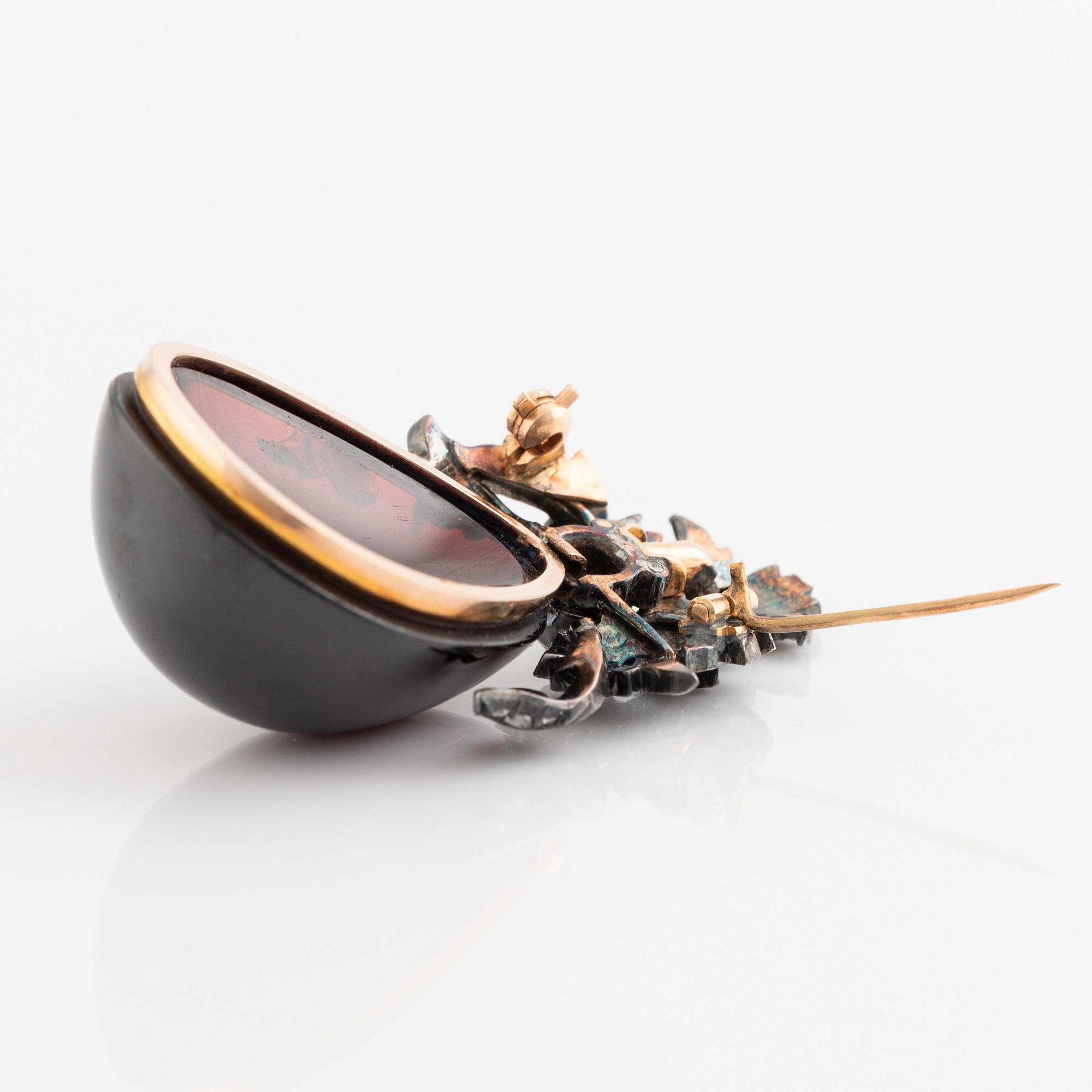 A silver and gold brooch set with a large carbuncle garnet. - Bukowskis