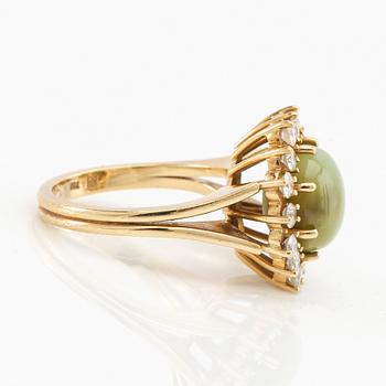 Ring in 18K gold with cabochon-cut cat's eye chrysoberyl and round brilliant-cut diamonds.