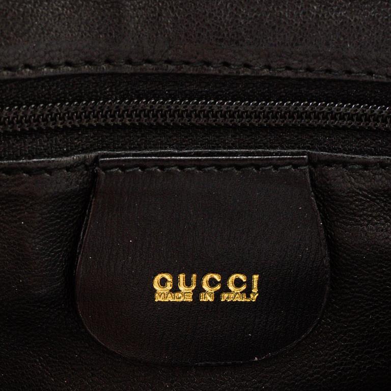 A Gucci patent leather bag with bamboo handle.
