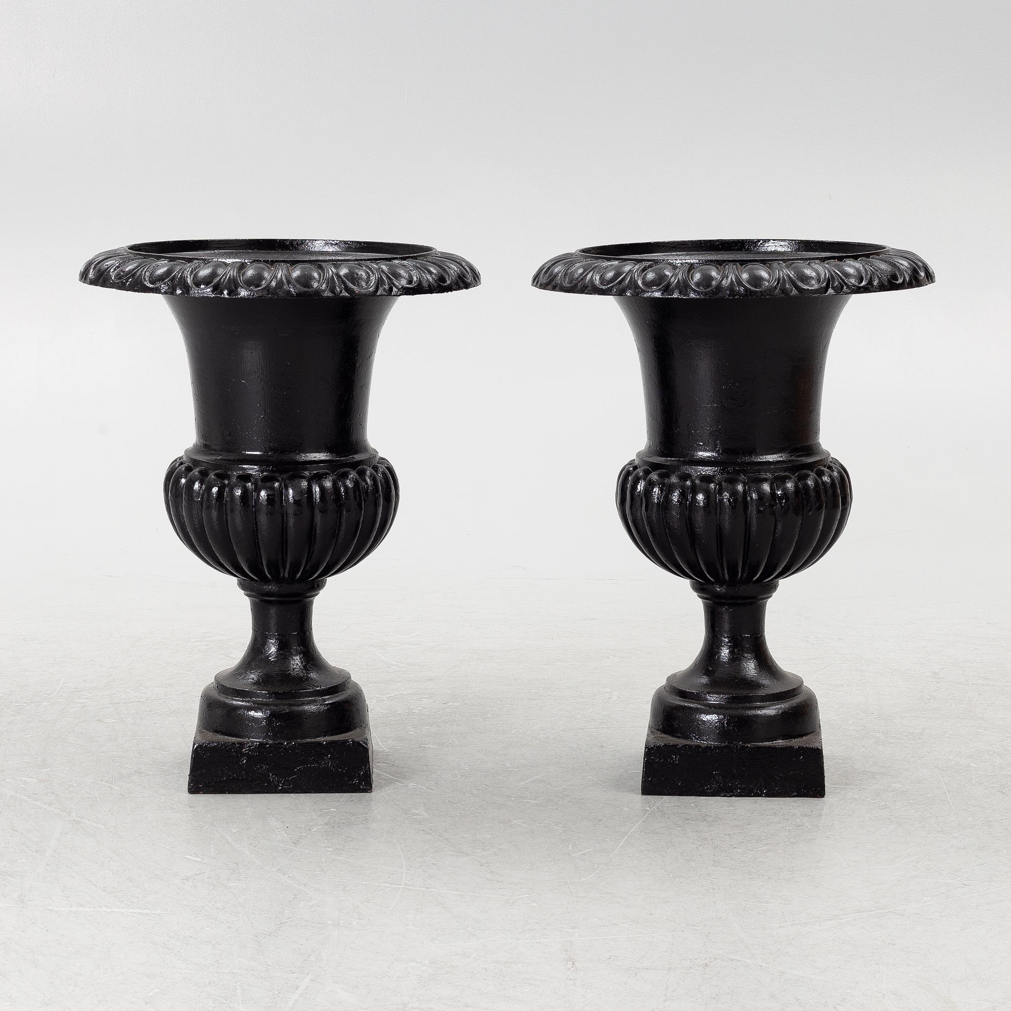A pair of cast iron garden urns, 20th century.
