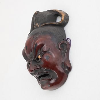 A Japanese lacquered wooden mask, 20th century. Signed.