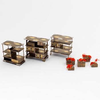 A group of Japanese lacquered miniature furniture and boxes in wooden crates, early 20th Century.