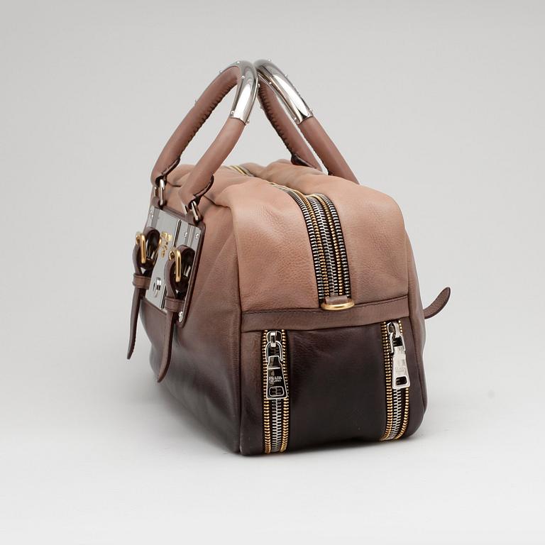 PRADA, a brown leather top handle bag.