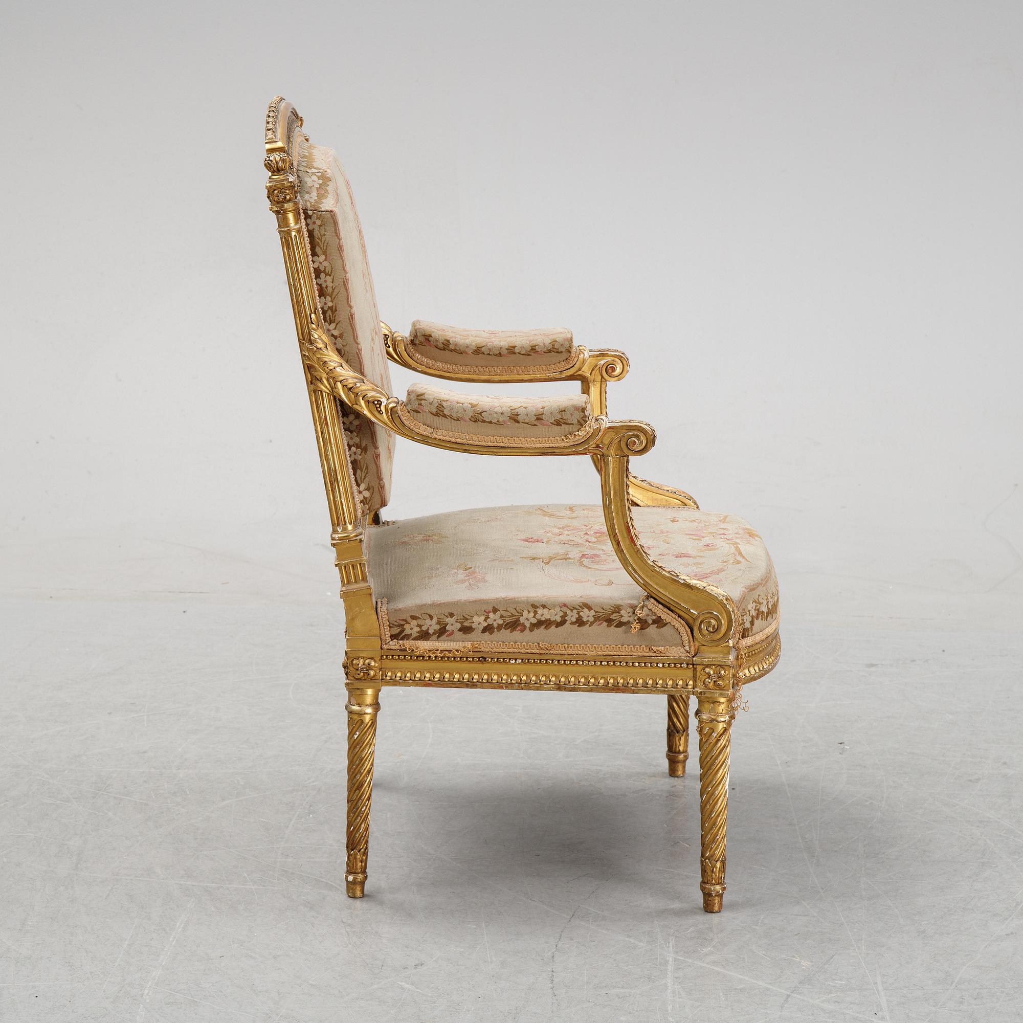 A gilt Louis XVI style armchair from around the year 1900.