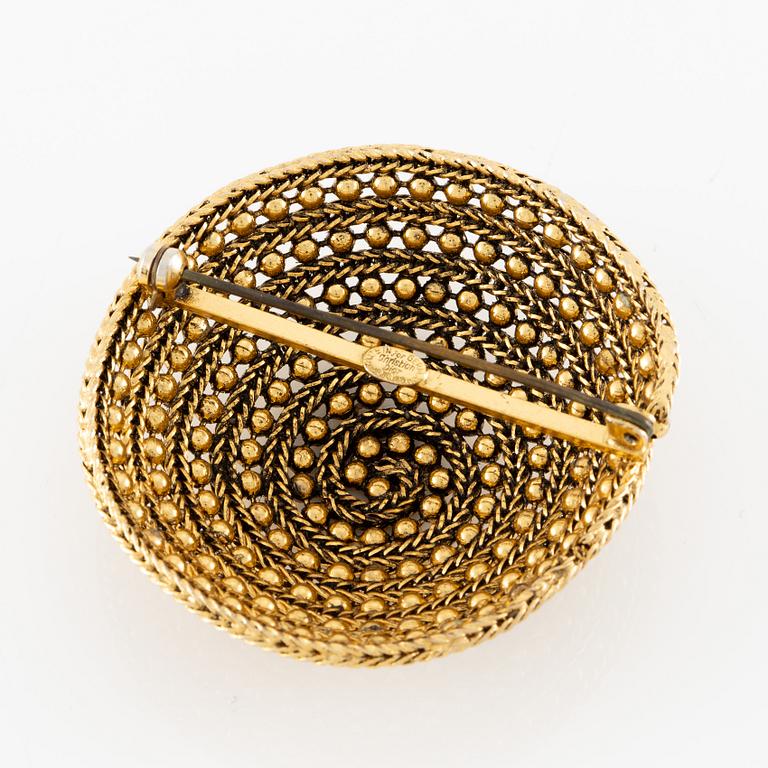 Christian Dior, A gold tone domed vintage brooch, 1963.